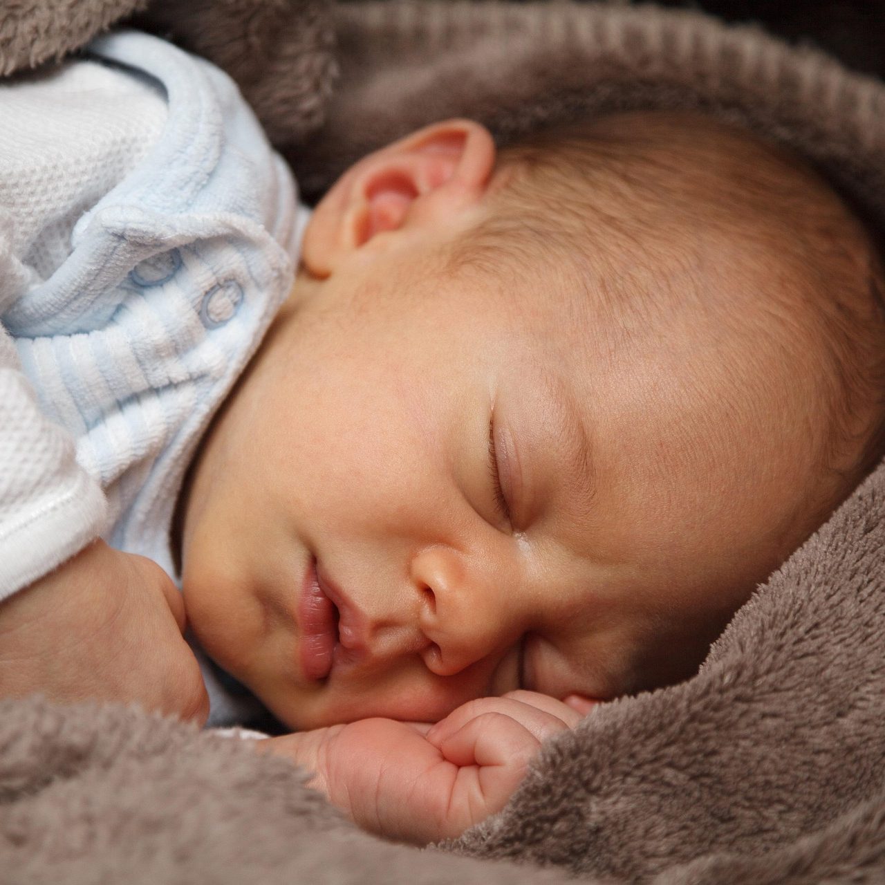 Schlafendes Baby, eingekuschelt in eine weiche Decke.